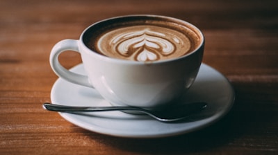 white ceramic teacup with coffee latte art