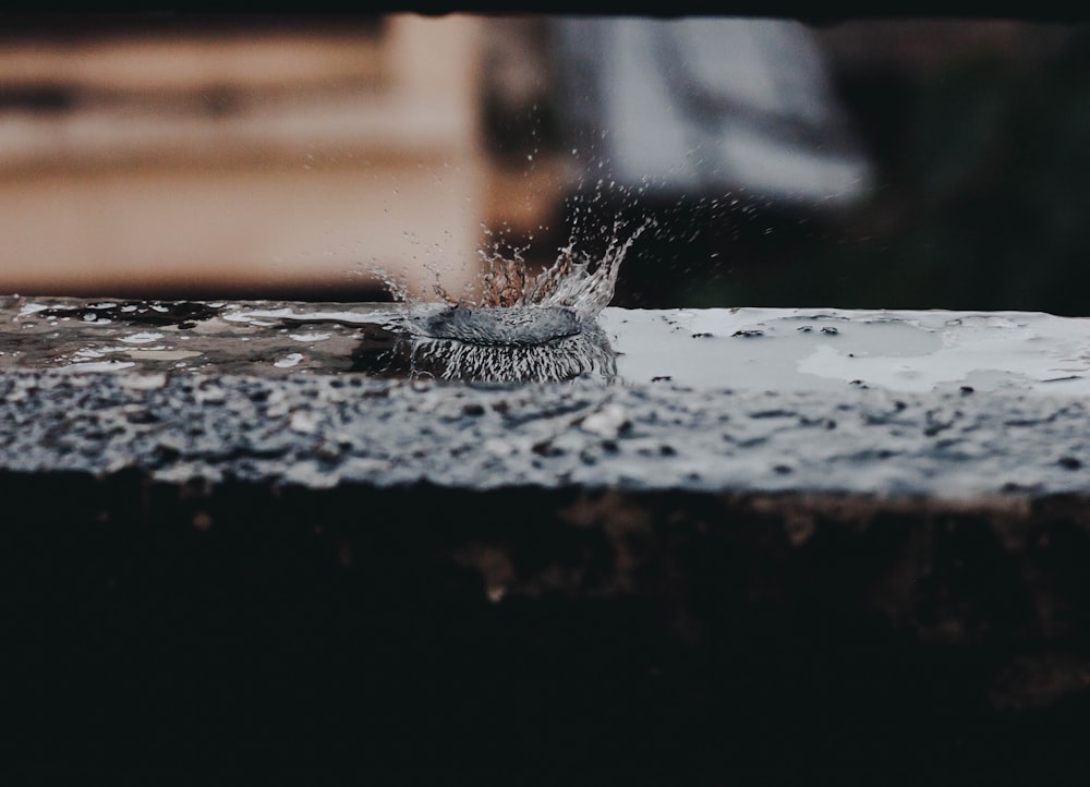 a black and white photo of water splashing on a table