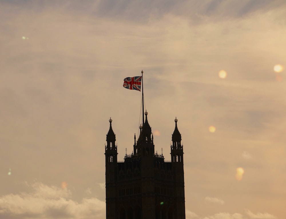 silueta de un edificio de 3 torres con la bandera del Reino Unido