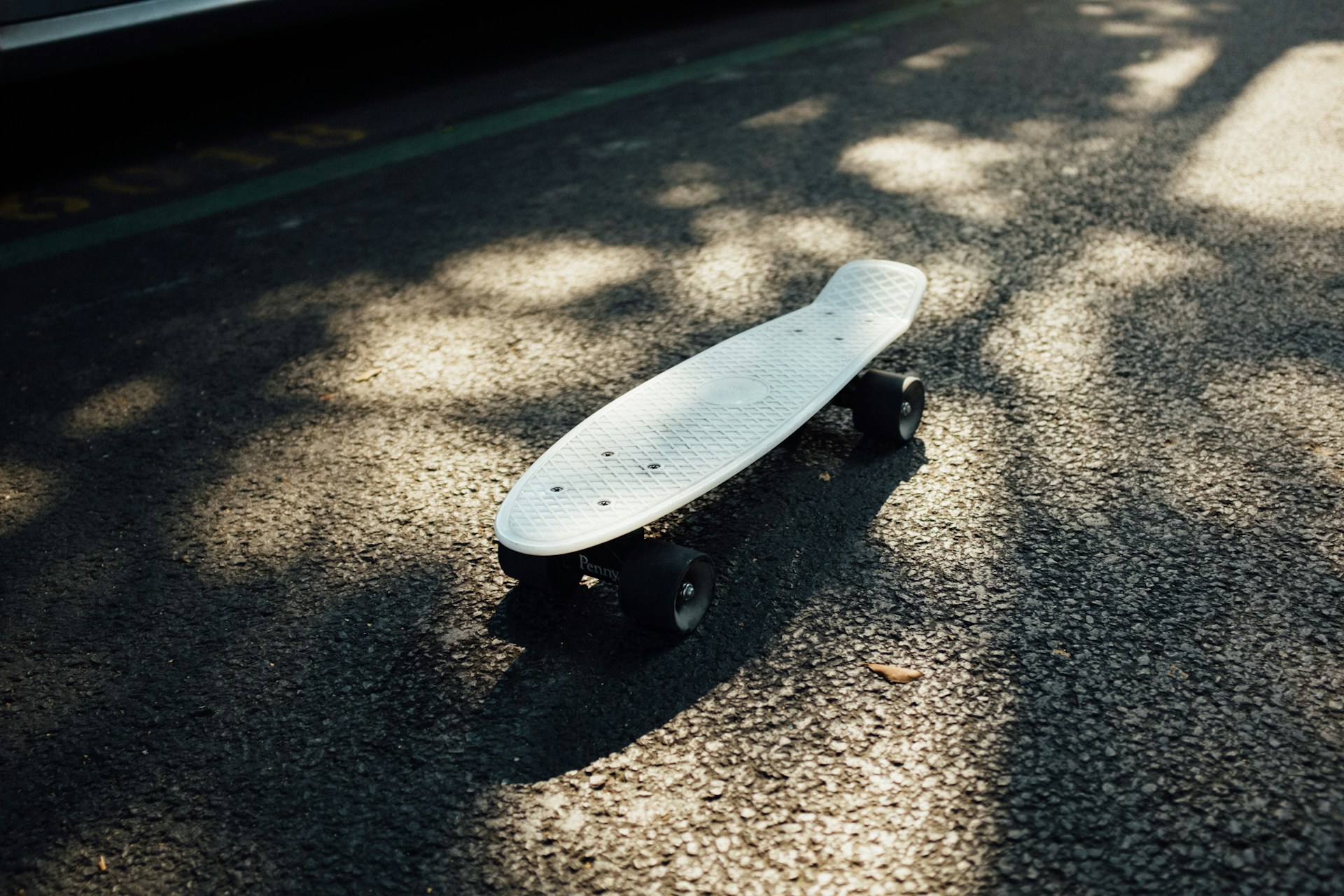 gray longboard on gray asphalt road