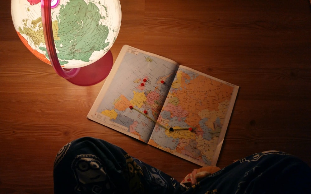 Weltkarte in der Nähe des Schreibtisches Globus auf brauner Holzplatte