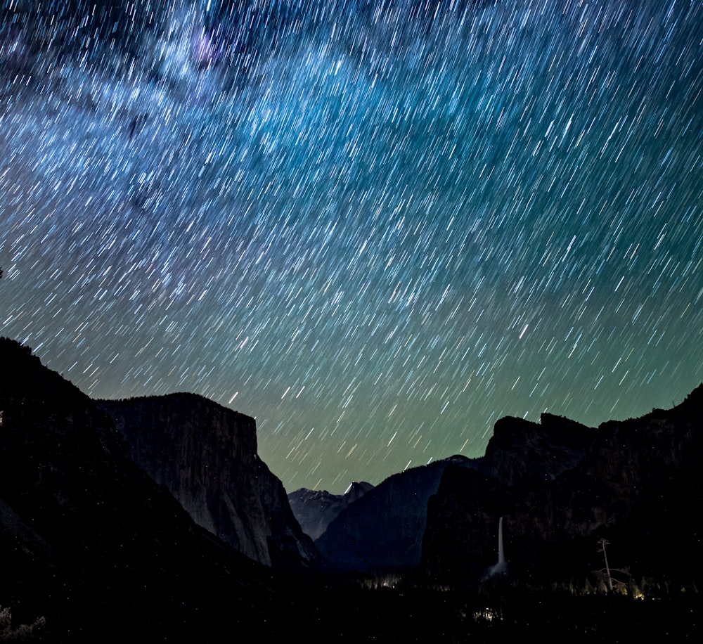 silhouette of mountains under night sky with stars
