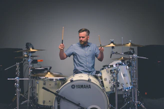 man holding drum sticks with sitting on throne