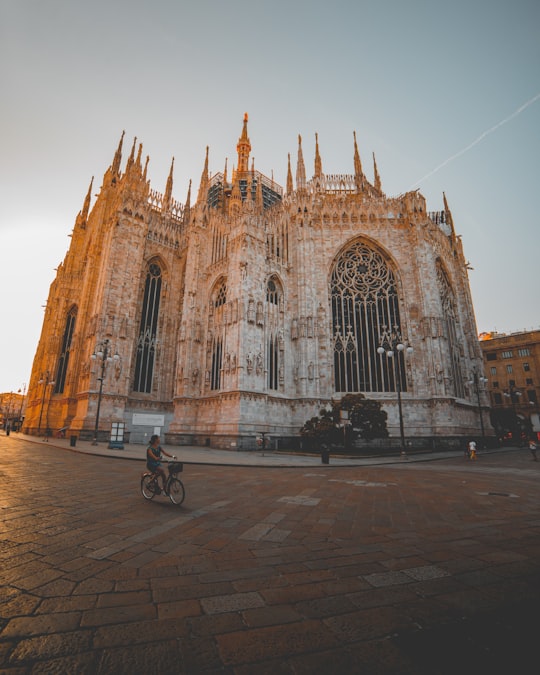 person riding bike near building in Duomo di Milano Italy