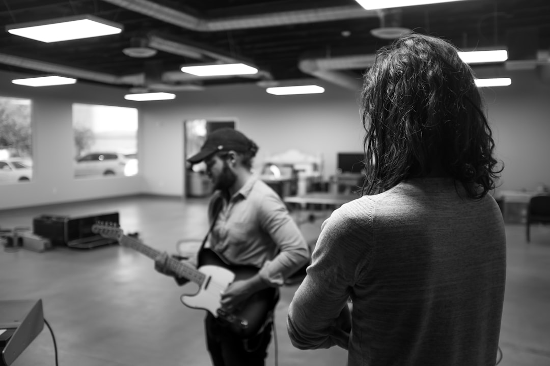 man playing guitar grayscale photo