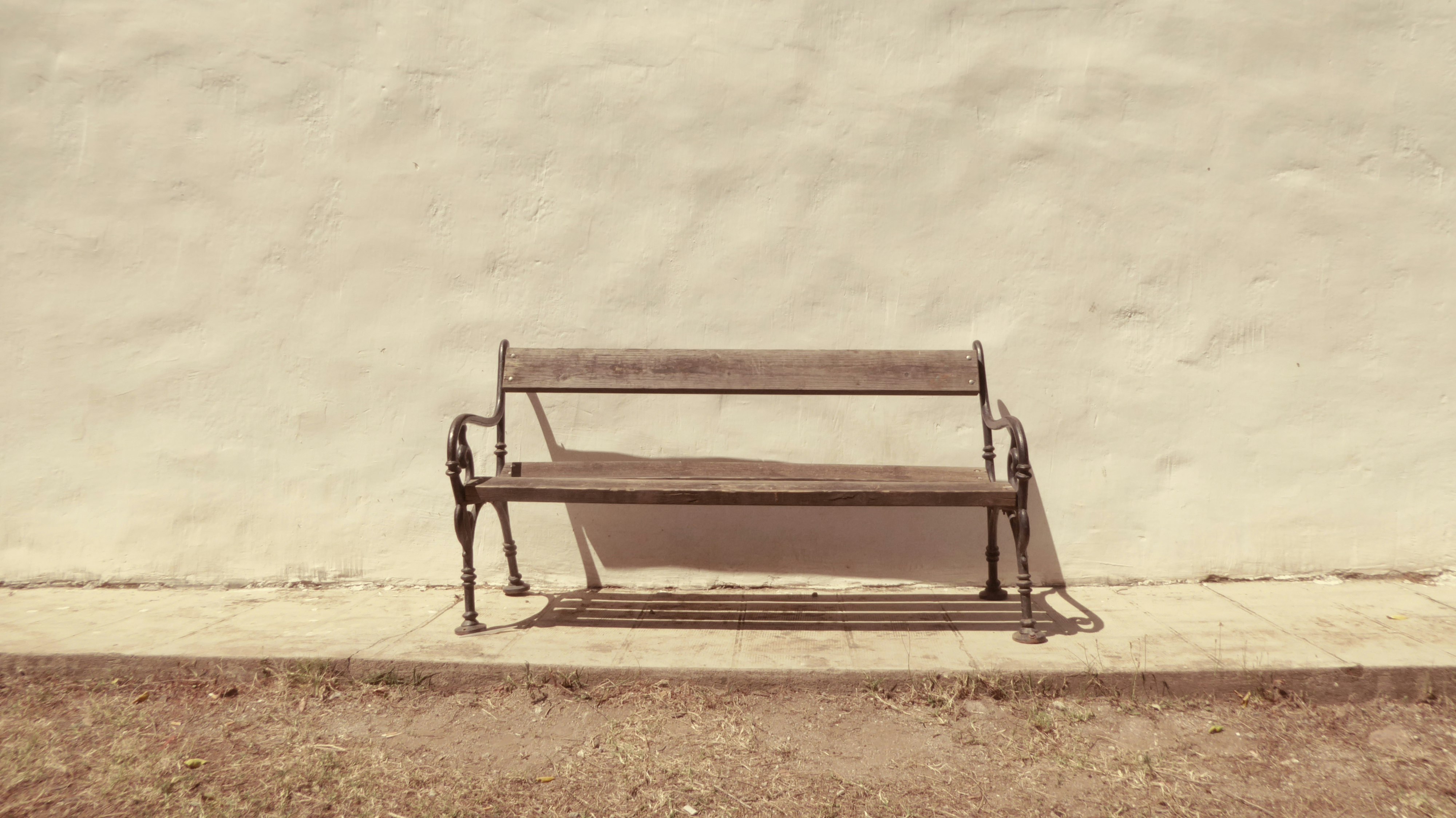 black bench in front of white wall