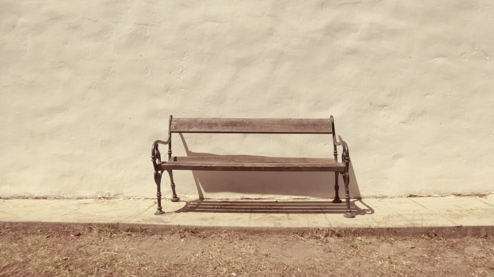 black bench in front of white wall