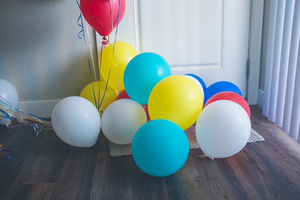 balões de cores variadas no chão perto da porta fechada