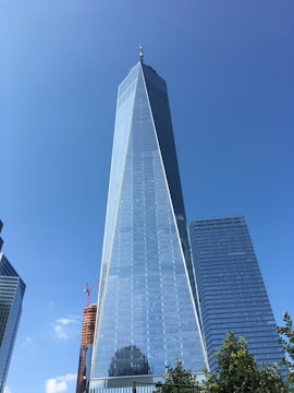 A panoramic view of a recently completed high-rise commercial building with glass facades under a clear blue sky.