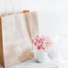 pink rose bouquet beside brown paper bag