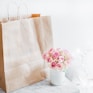 pink rose bouquet beside brown paper bag