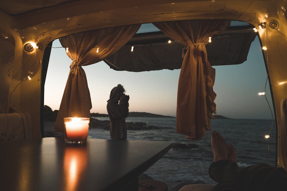 person lying on couch with body of water view at dusk