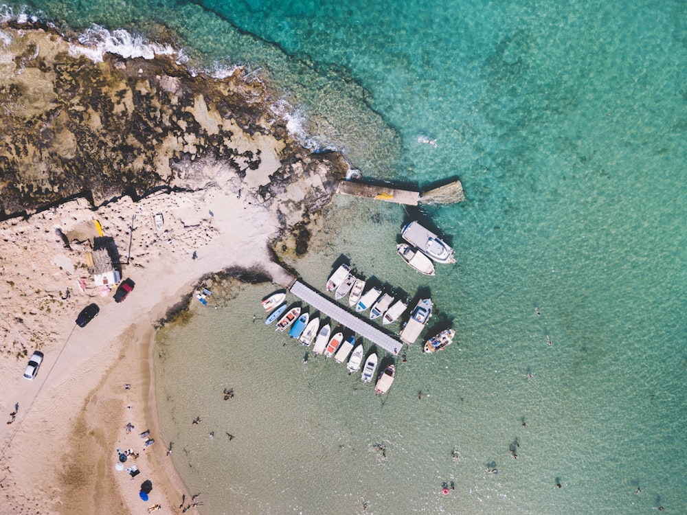an aerial view of boats docked at a beach