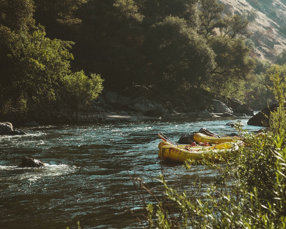 two yellow inflatable boats beside river at daytime