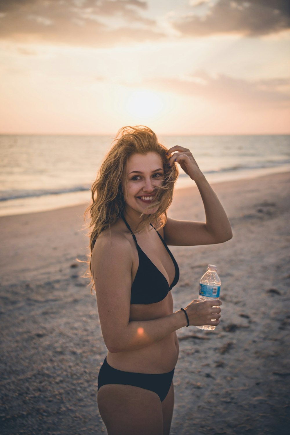 woman in black bikini standing near ocean