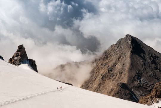 people walking on mountain alps with clouds in Gran Paradiso Italy