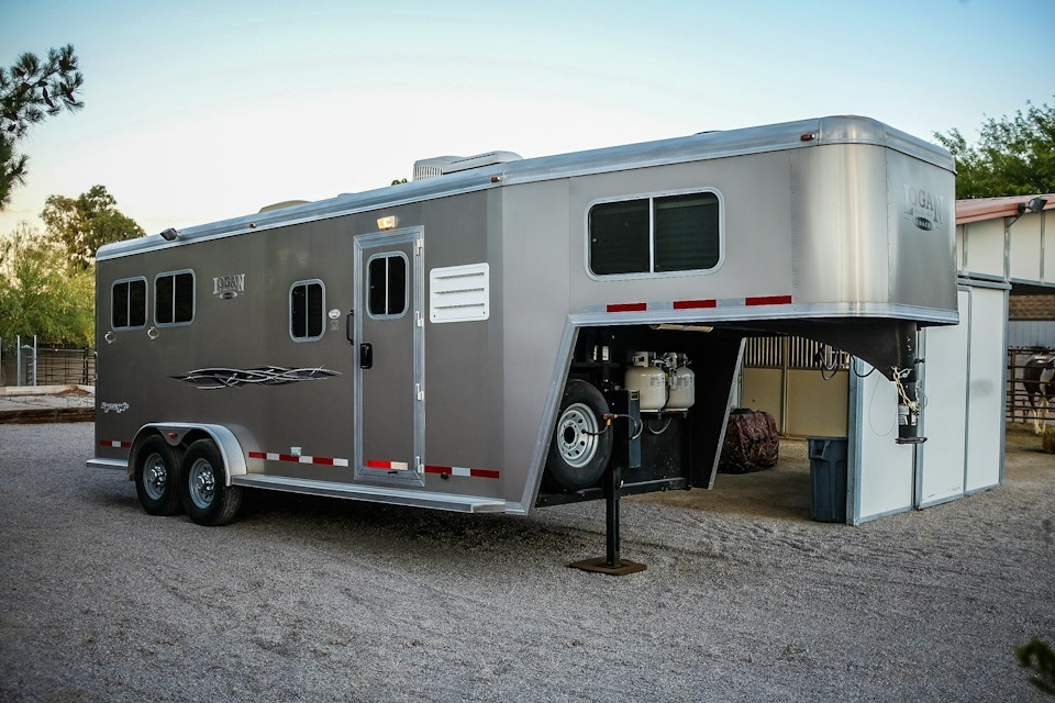 Gooseneck enclosed trailer with living quarters parked on a gravel lot for enclosed trailer title loans