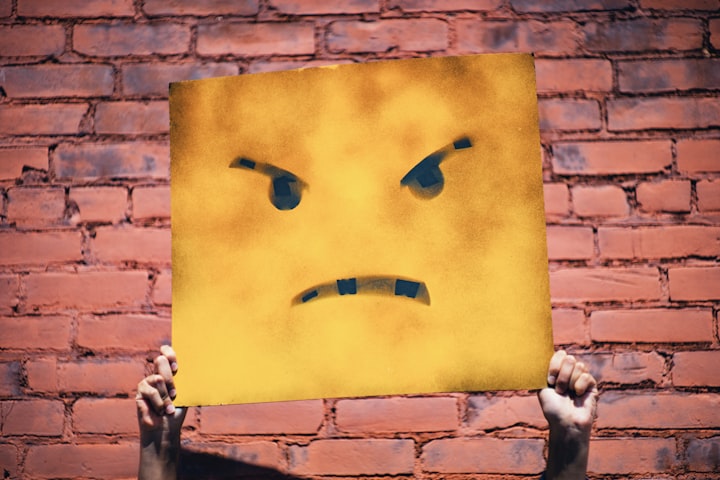 Angry face on a block in front of a brick wall