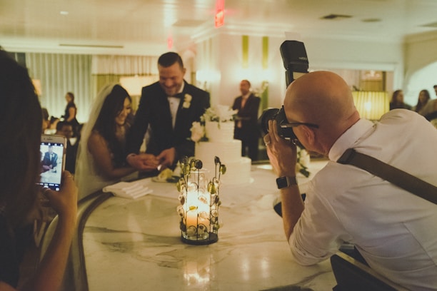 Guests happily uploading wedding photos on a website using their phones.