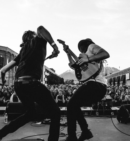 grayscale photo of man playing guitar