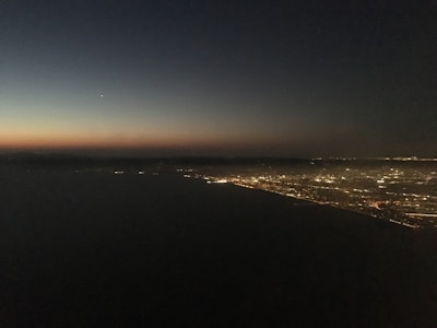 Abstract AI neural network pattern overlaid on a city skyline at dusk with glowing data points.