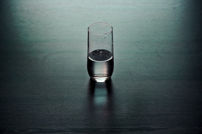 clear drinking glass on brown wooden surface