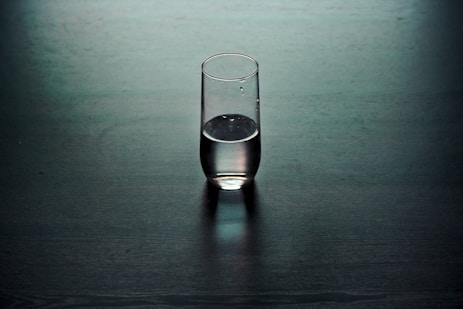 clear drinking glass on brown wooden surface