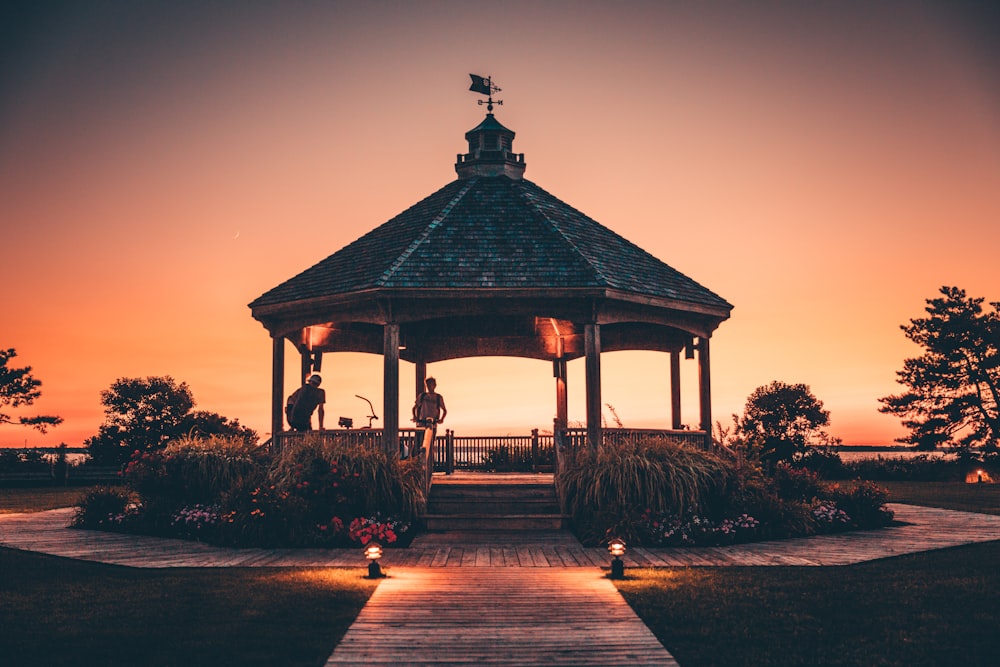 People with bicycles inside a park pavilion at sunset