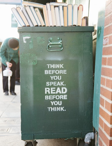 books over green trolley bin