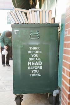 books over green trolley bin