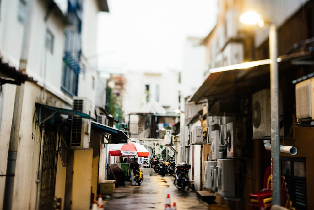 a narrow alley with a red and white awning