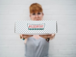 woman showing Krispy Kreme box