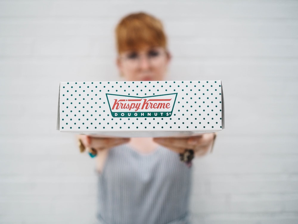 woman showing Krispy Kreme box