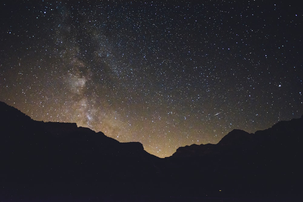mountain silhouette under stars at nighttime
