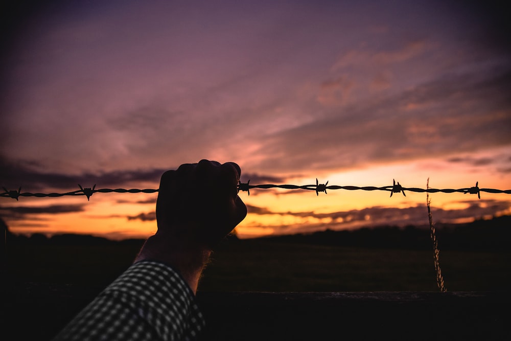 person holding barb wire