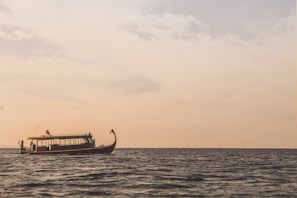 Close-up of a boat’s bow slicing through gentle waves with a bright horizon
