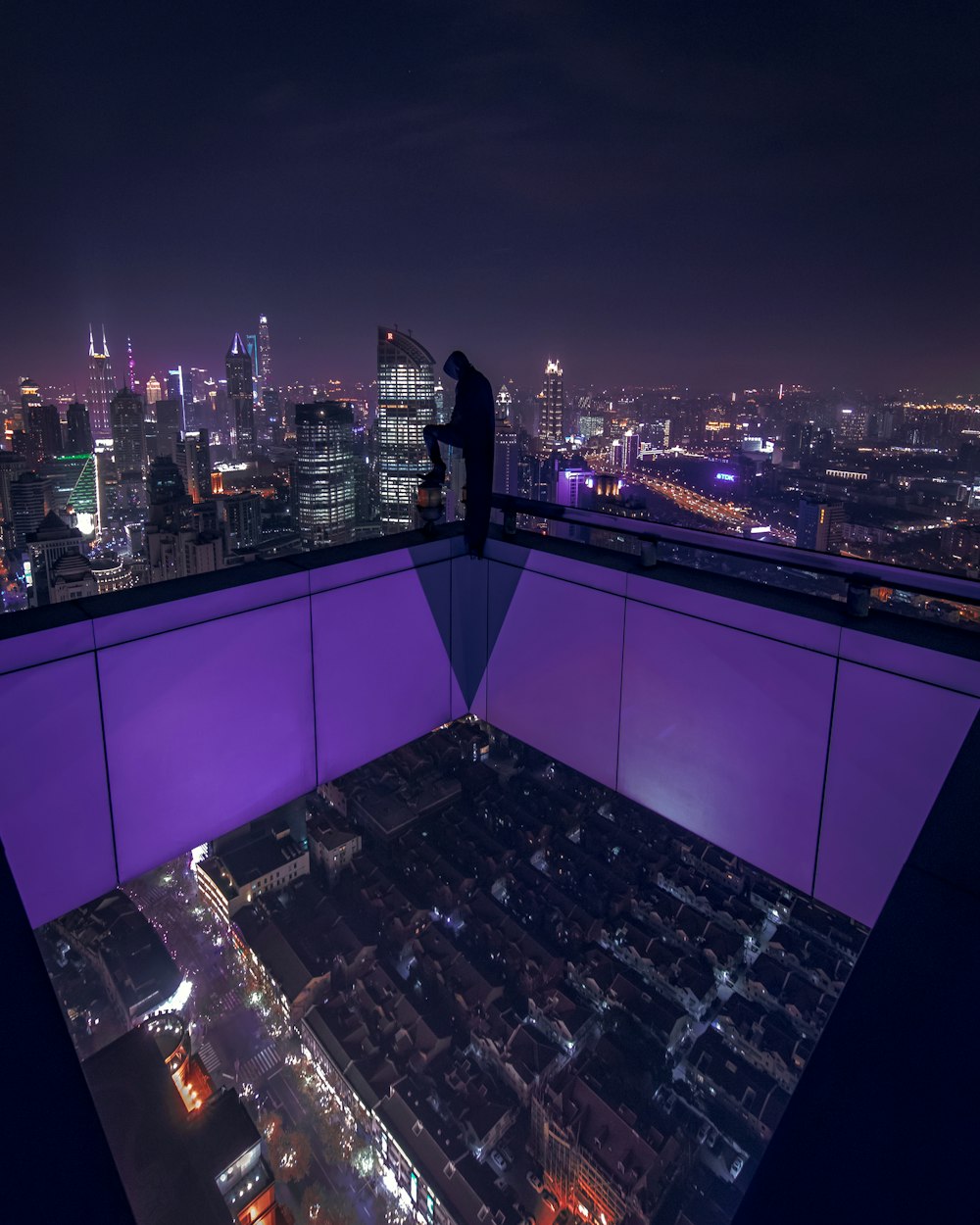 man standing on building rooftop during nigh time