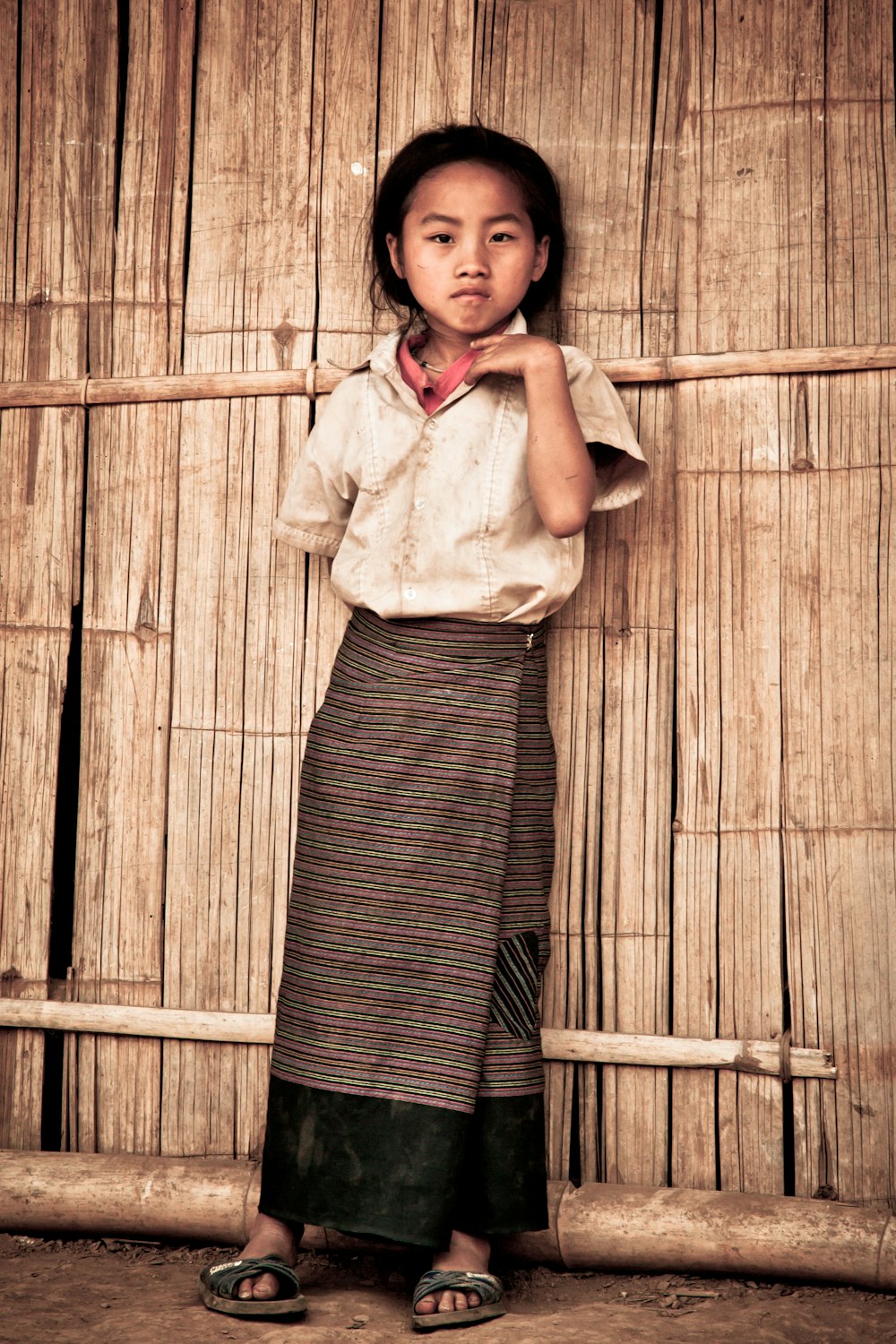 girl standing leaning on house's wall