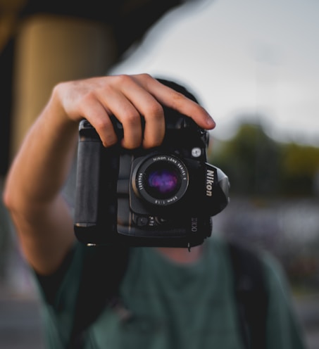 person holding Nikon DSLR camera