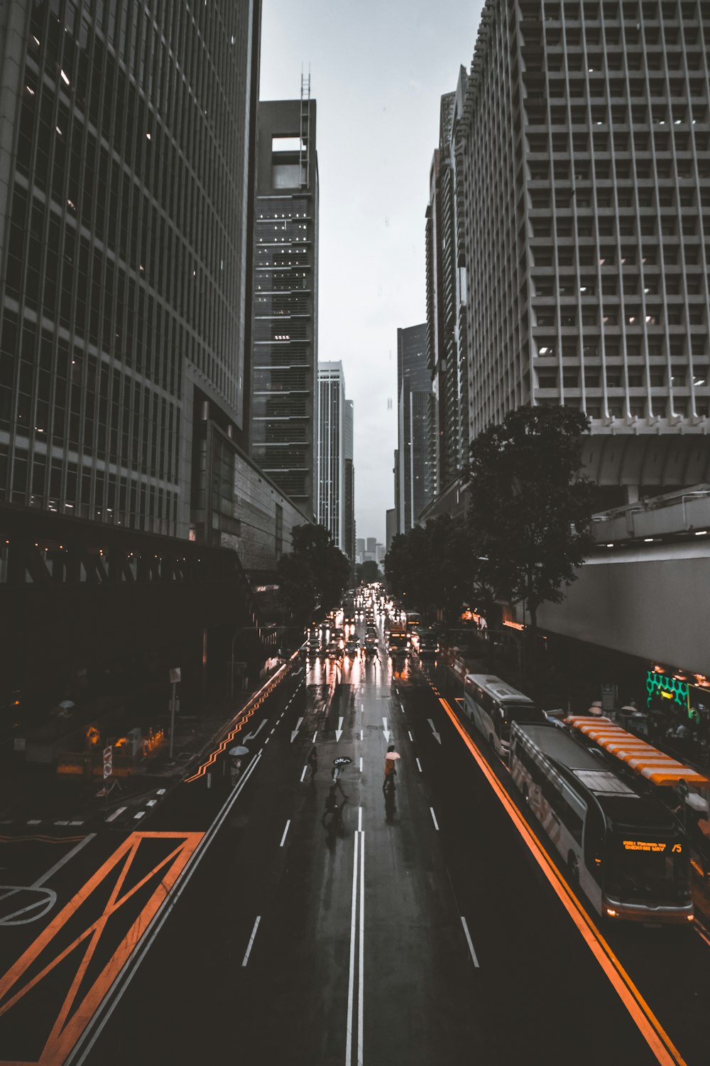 people crossing road between high-rise buildings