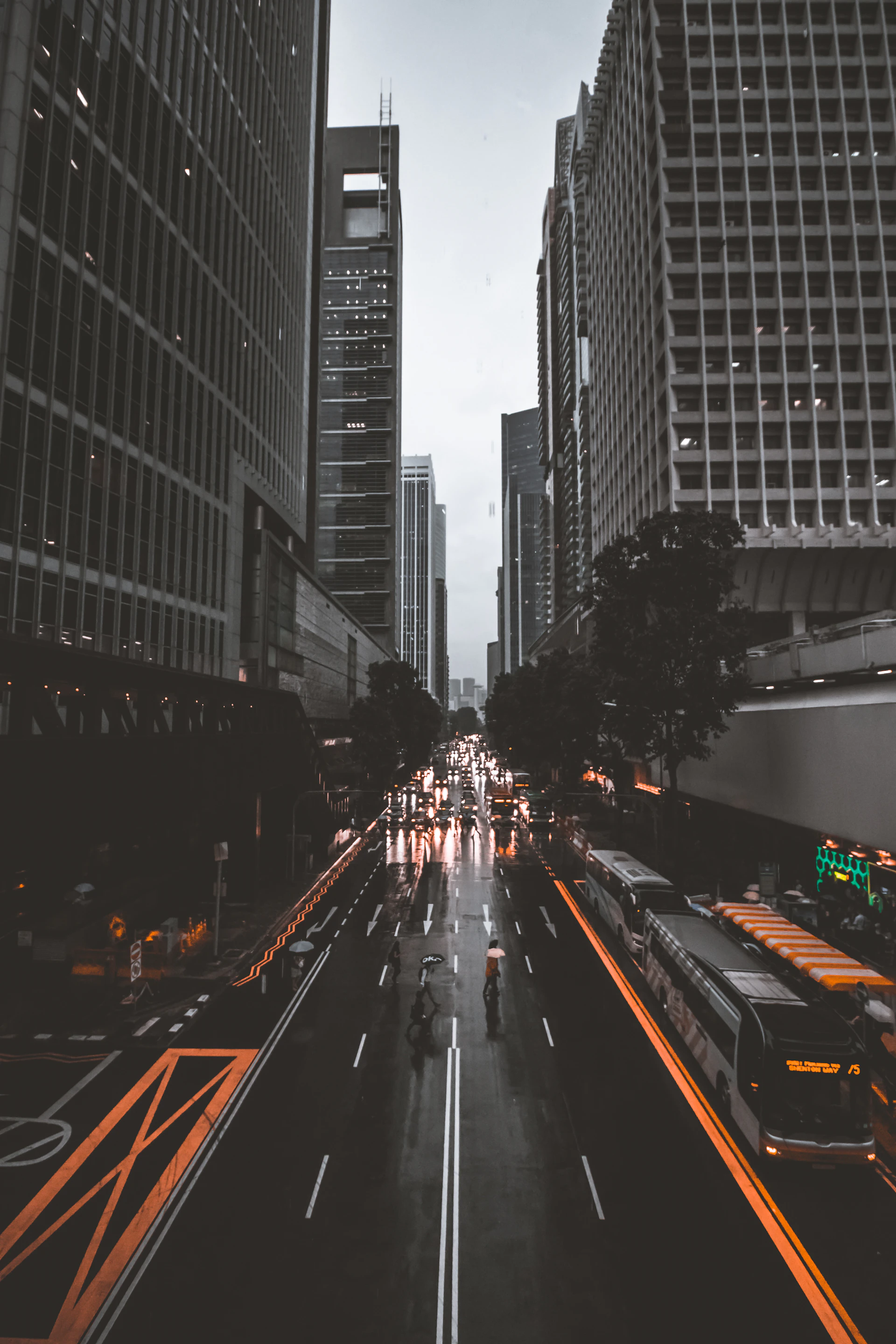 people crossing road between high-rise buildings