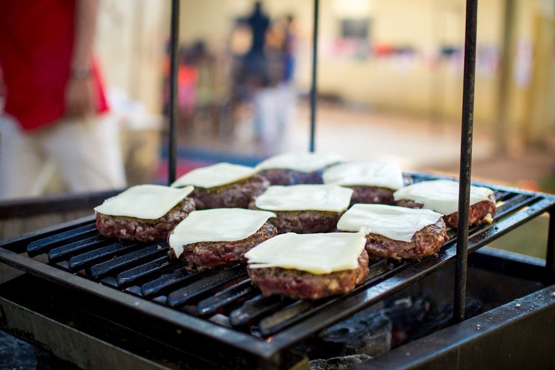 selective focus photography of meat patty with cheese on grill