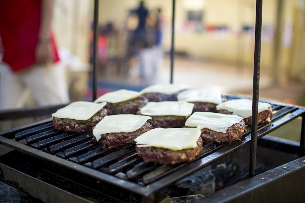 selective focus photography of meat patty with cheese on grill