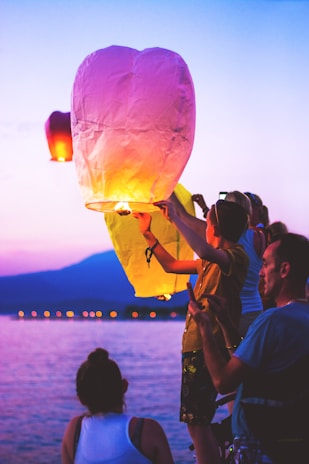 A sunset scene with people releasing colorful balloons as a symbol of hope and kindness.