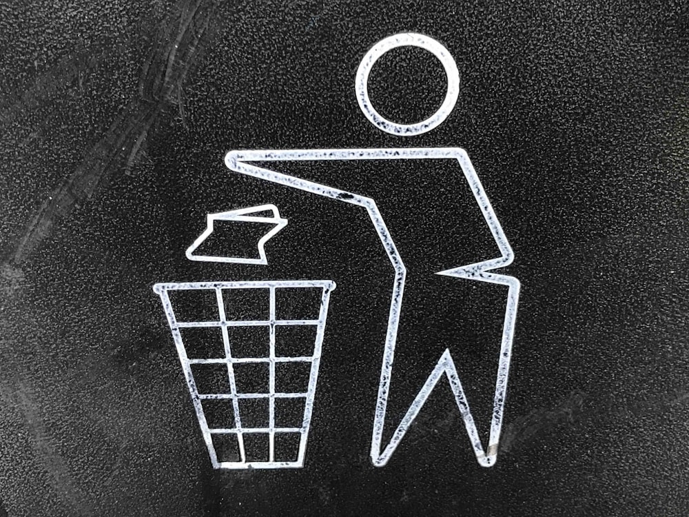 A chalk drawing of a person throwing garbage into a basket.