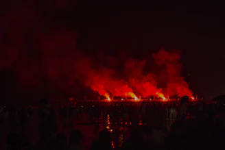 Display shells glowing in a staged test firing under night sky.