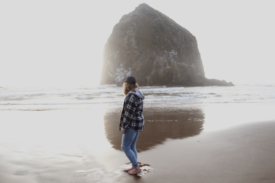 woman seashore beside hill in Cannon Beach United States