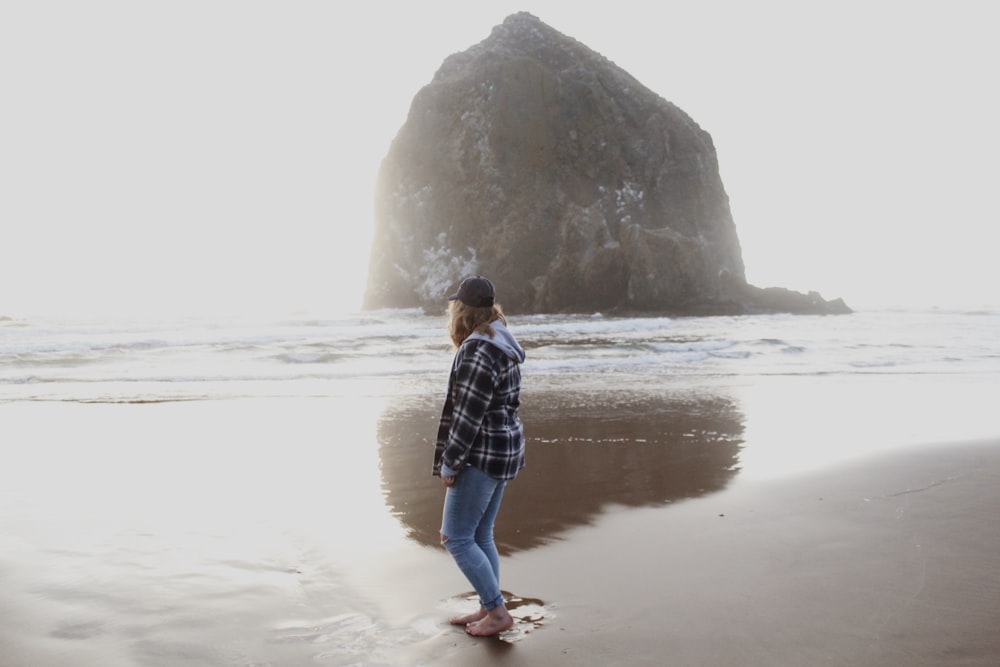 woman seashore beside hill