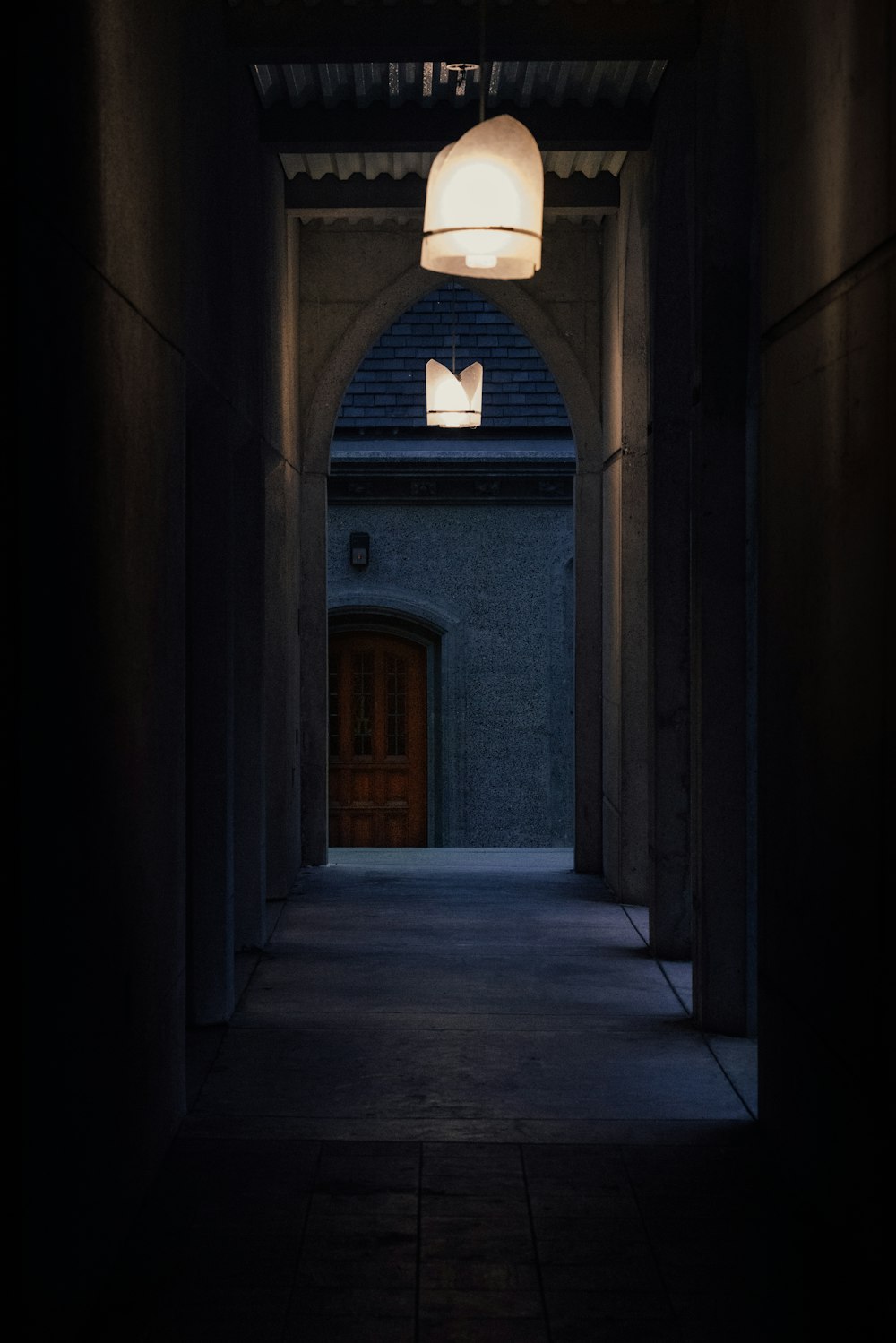 a dark hallway with a light hanging from the ceiling
