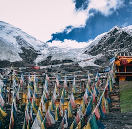 multicolored streamers near snow mountain under blue and white cloudy sky